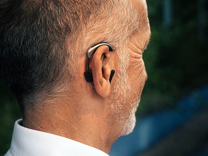 ForgTin®-Ohrbügel zur Tinnitus-Therapie am Ohr eines Mannes. Copyright: Richard Schabetsberger